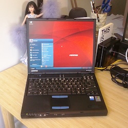 A Compaq Evo laptop turned on showing Windows XP