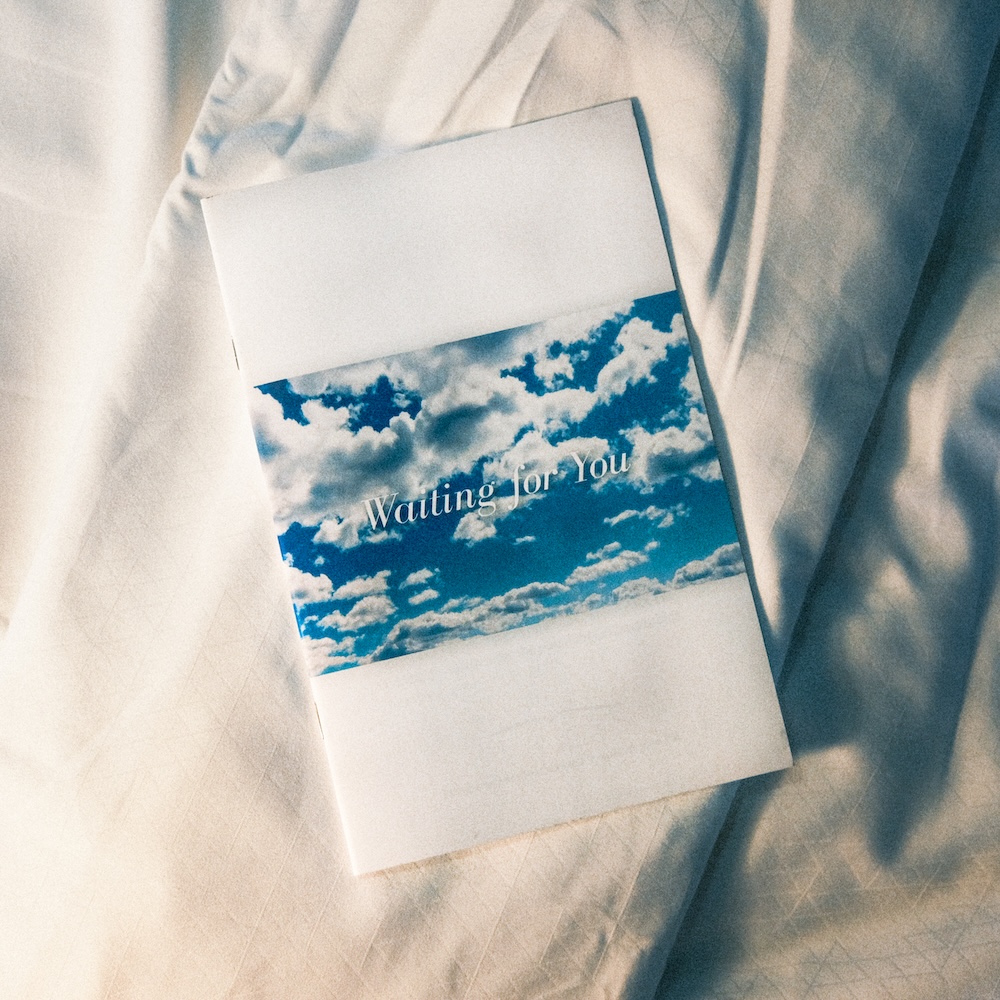 'Waiting for You' zine cover, a white square with a horizontal photo in the middle of the sky with clouds in it. Overlaid on the photo in white italic serif text are the words Waiting for You.